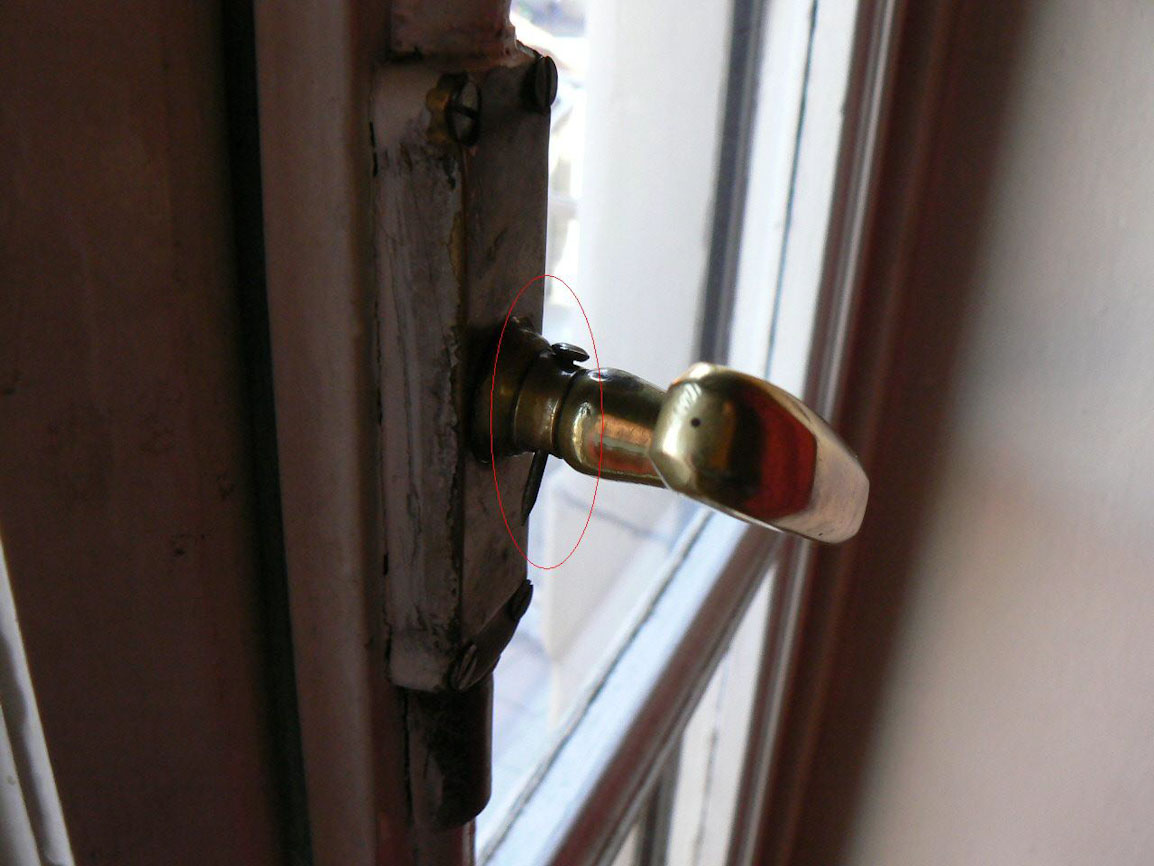 Single-pane window with a nail in the handle