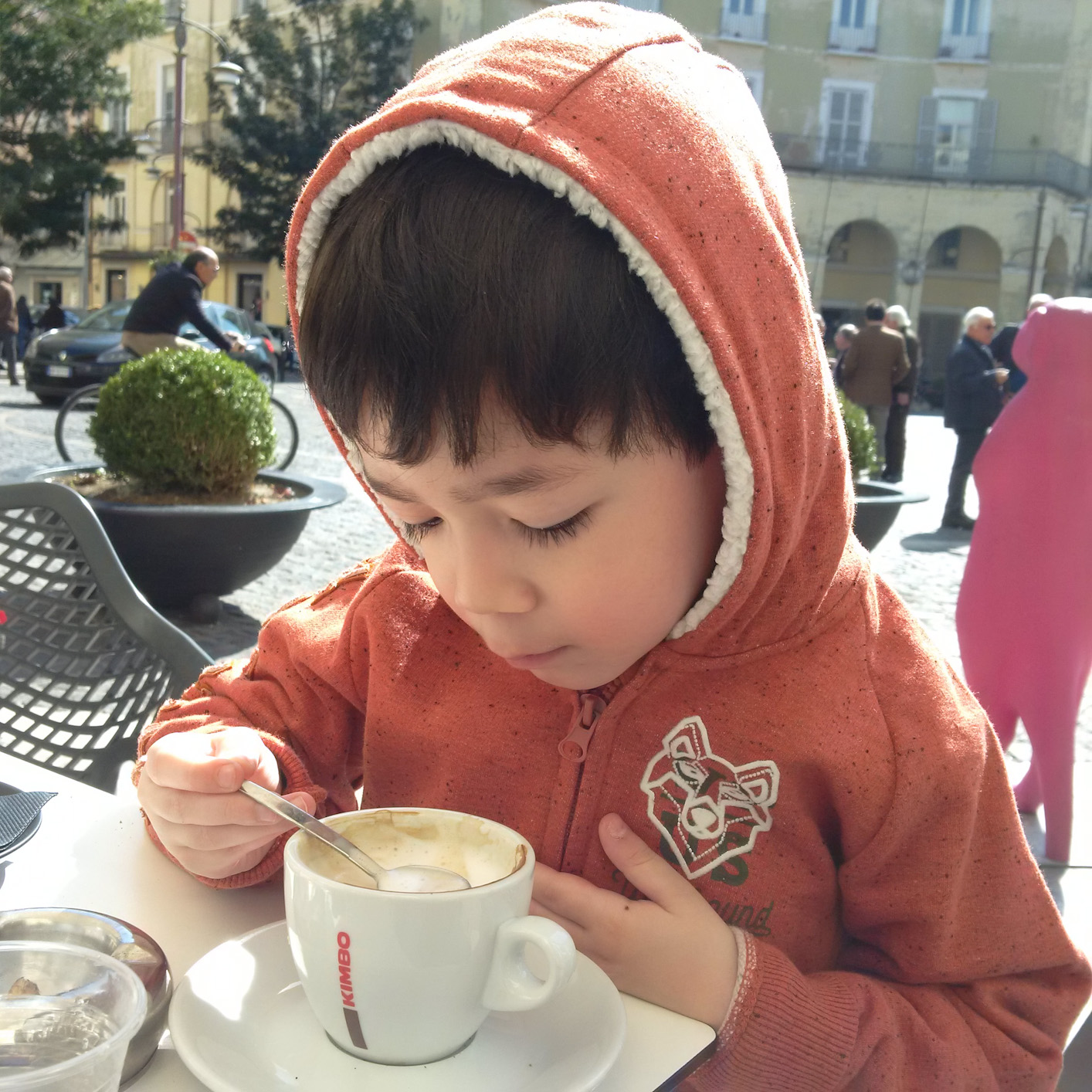 Child drinking cappuccino at a cafe